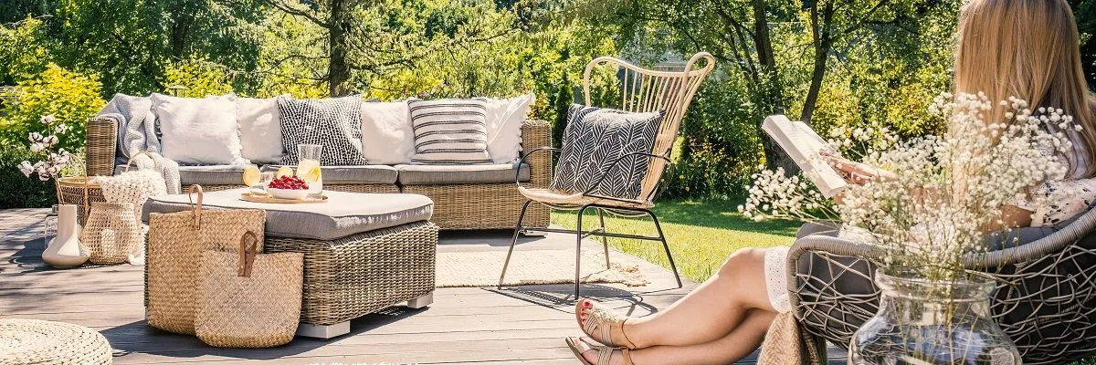 woman-reading-a-book-on-patio-with-rattan-table-4WRMHC3 res